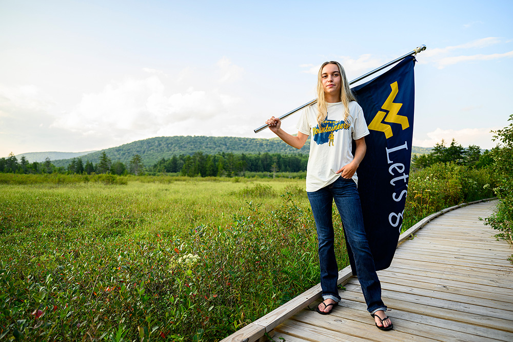 Amelia Rose poses with a WVU flag at Cranberry Glades.